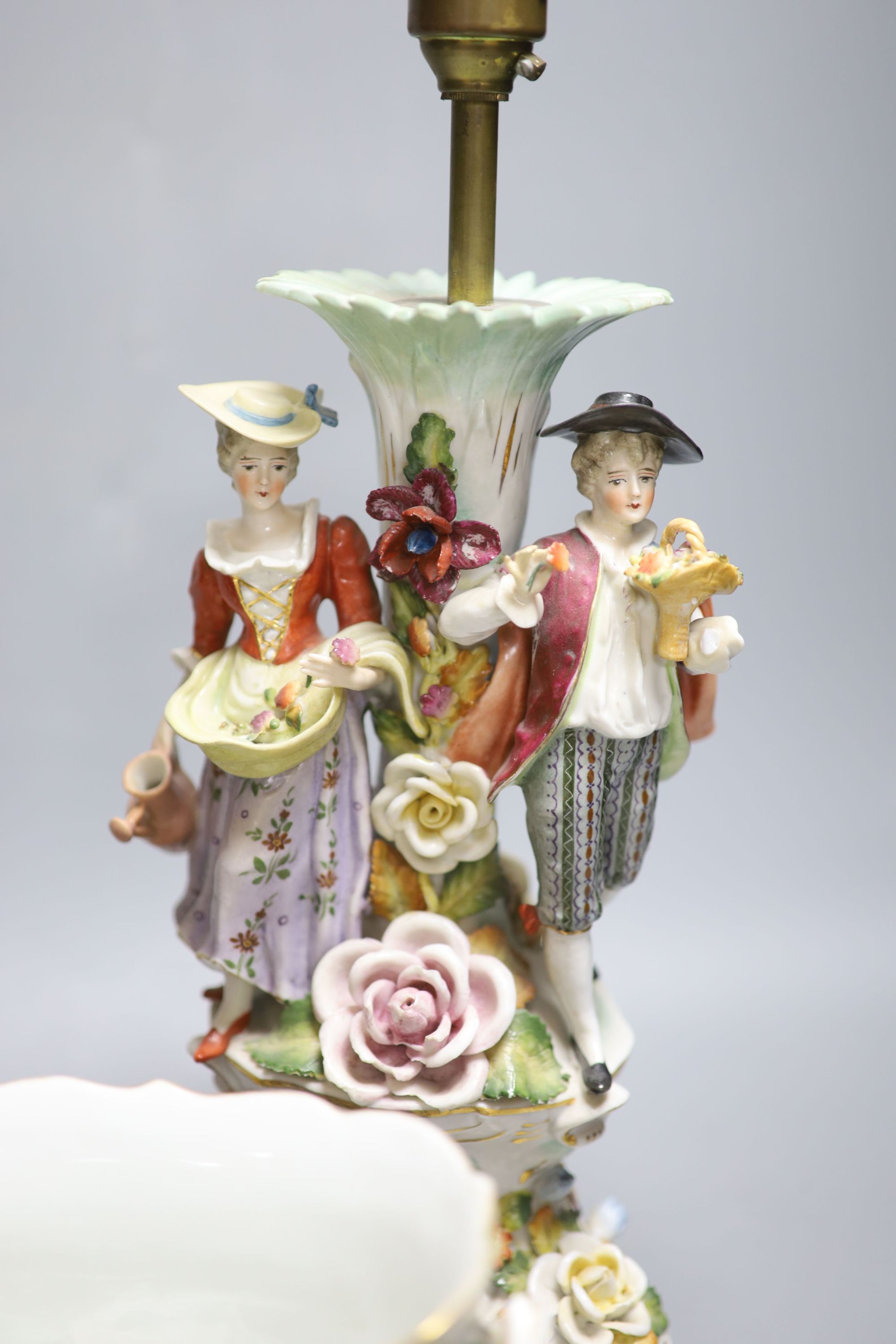 A Dresden figurative lamp, another similar lamp and a bowl with swags of flowers, tallest 28cm